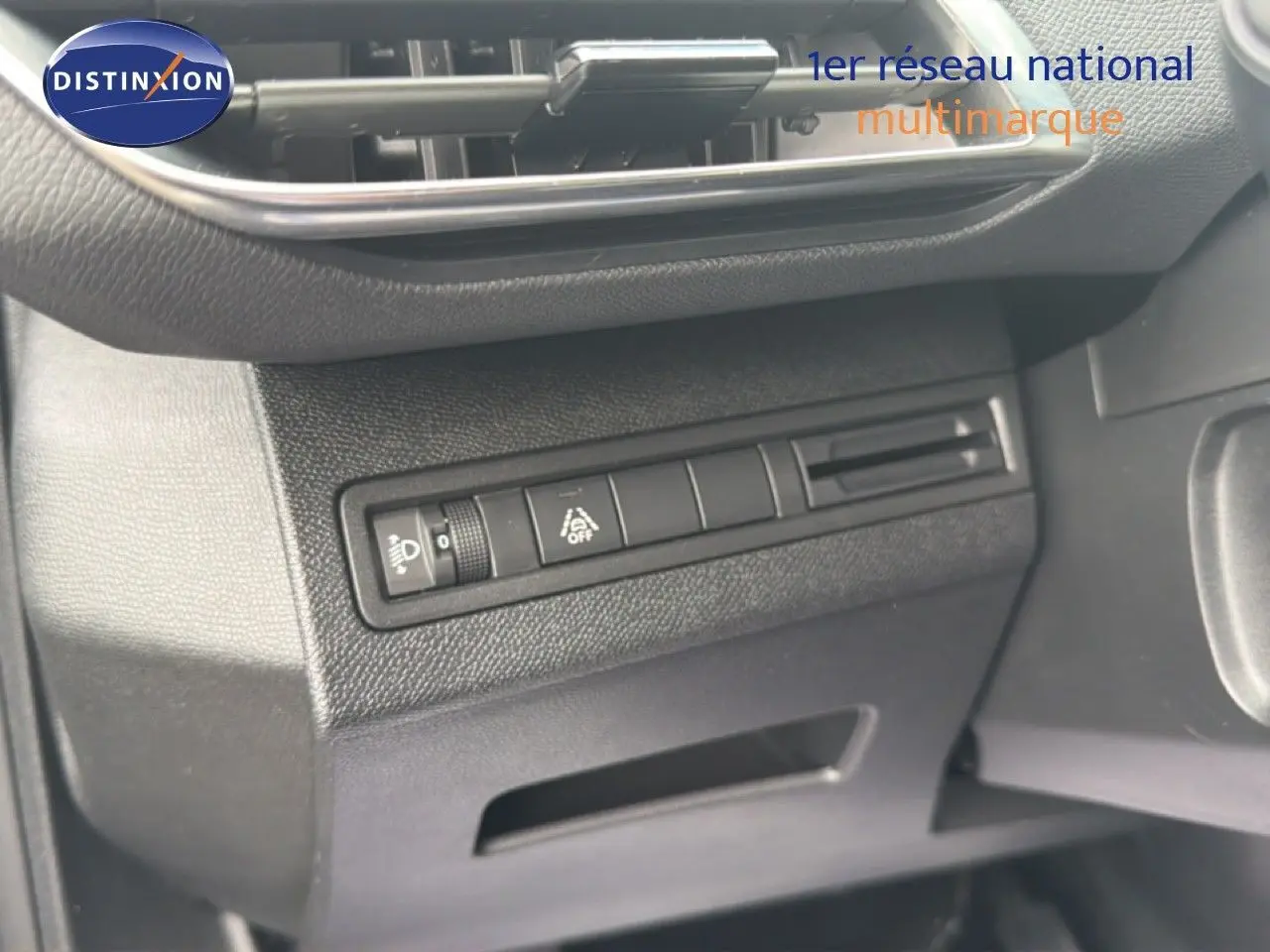Détail du tableau de bord noir du Peugeot 5008 Hybrid 2024, avec commandes d'éclairage et aide à la conduite.