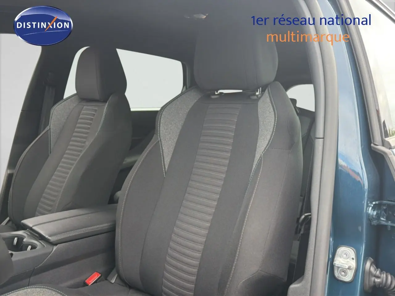 Vue intérieure sur les sièges avant en tissu gris noir du Peugeot 5008 bleu Célèbes métal, porte avant droite ouverte.