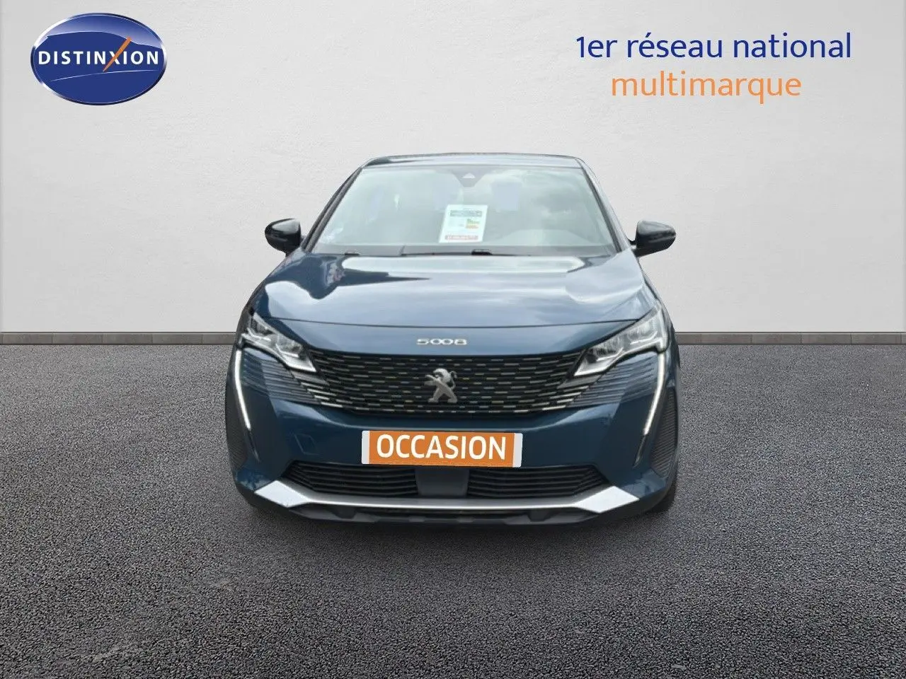 Vue frontale d'un Peugeot 5008 bleu Célèbes métal avec calandre noire et plaque "OCCASION" visible.
