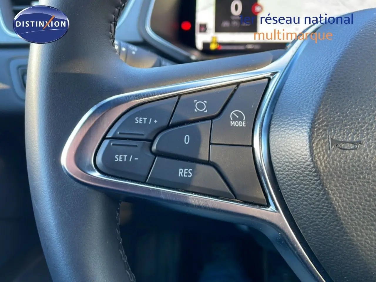 Gros plan sur les commandes au volant côté gauche du Renault Captur rouge désir métal avec toit noir, version 2025.