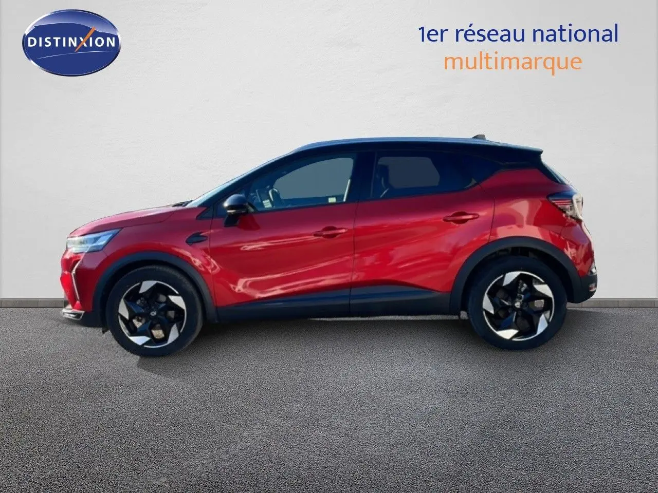 Profil droit du Renault Captur 2025 rouge désir métal avec toit noir, roues alliage et lignes modernes.
