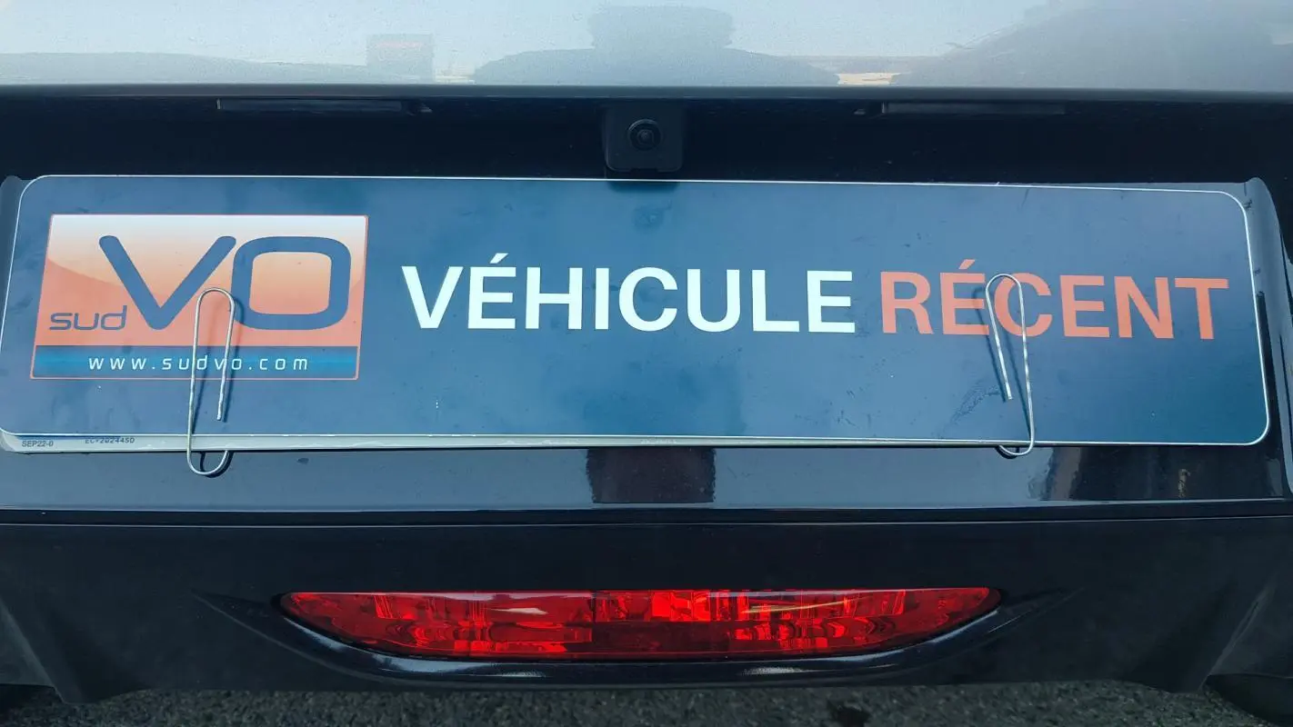 Gros plan sur la partie arrière grise d’une Peugeot 208 Hybrid 110 e-DCS6 Allure avec plaque « Véhicule récent ».