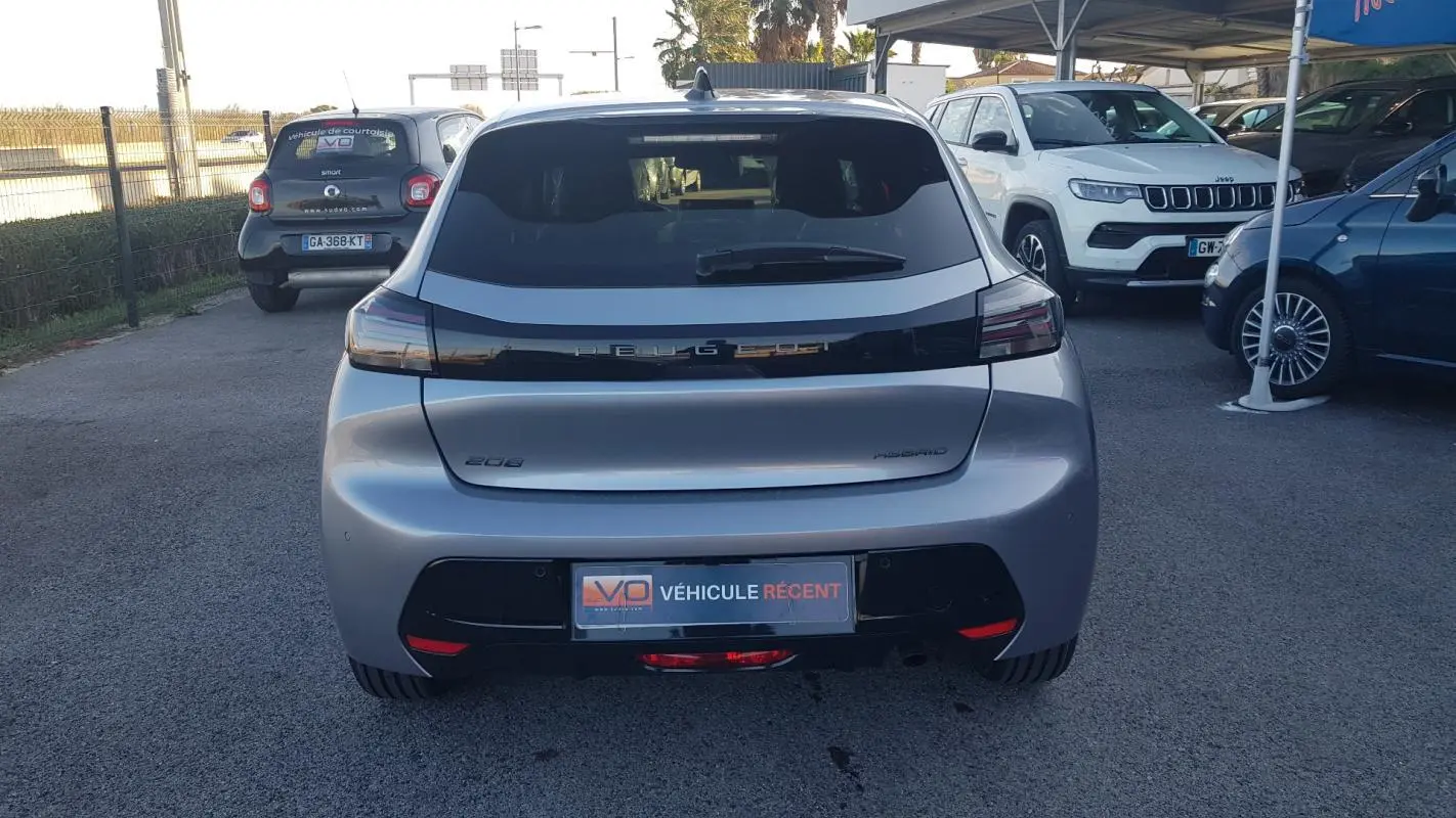 Vue arrière d'une Peugeot 208 Hybrid 110 gris métallisé avec feux arrière noirs et jantes alliage 16 pouces.