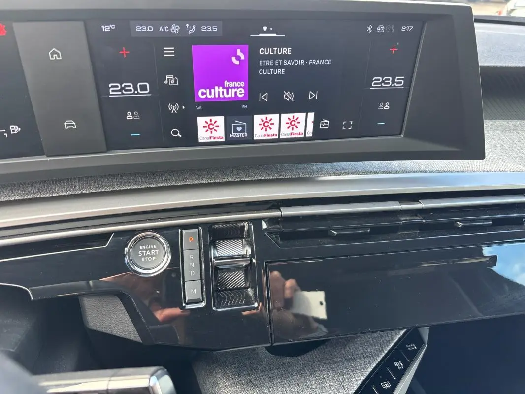 Vue rapprochée du tableau de bord du Peugeot 3008 Hybrid 145 e-DCS6 Allure gris, avec écran tactile et bouton start/stop.