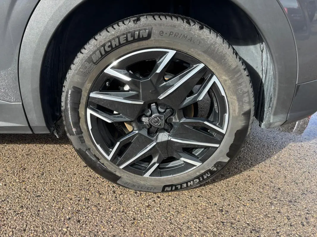Gros plan sur la jante alliage 19 pouces noire et argentée du côté avant droit du Peugeot 3008 gris 2025.