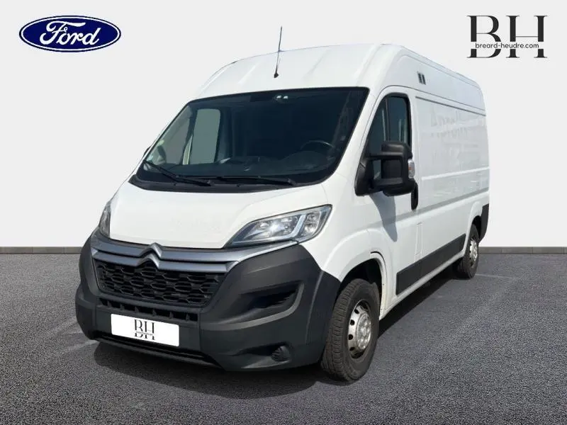 Vue 3/4 avant droite d'un utilitaire Citroën Jumper blanc Banquise avec pare-chocs noirs et double portes arrière.