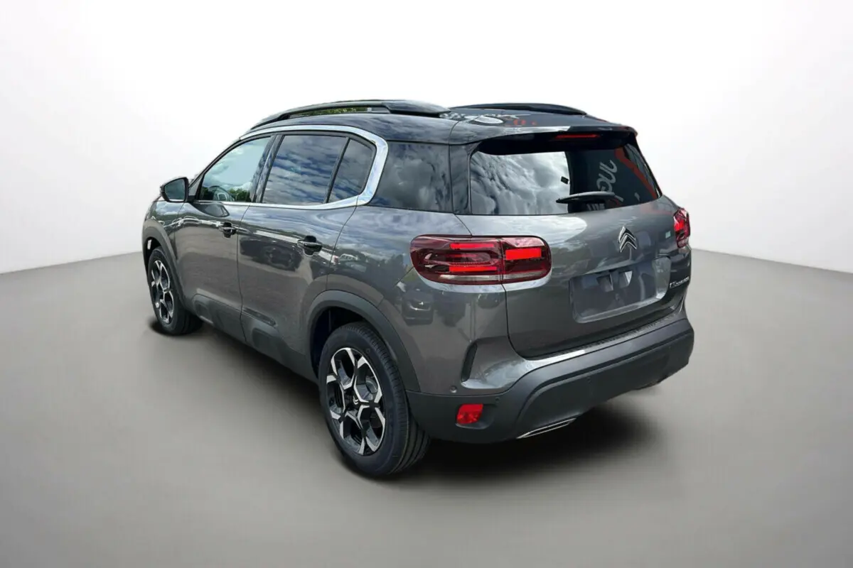 Citroën C5 Aircross Hybrid 2025 gris platinium avec toit noir, vue 3/4 arrière côté gauche, jantes distinctives.