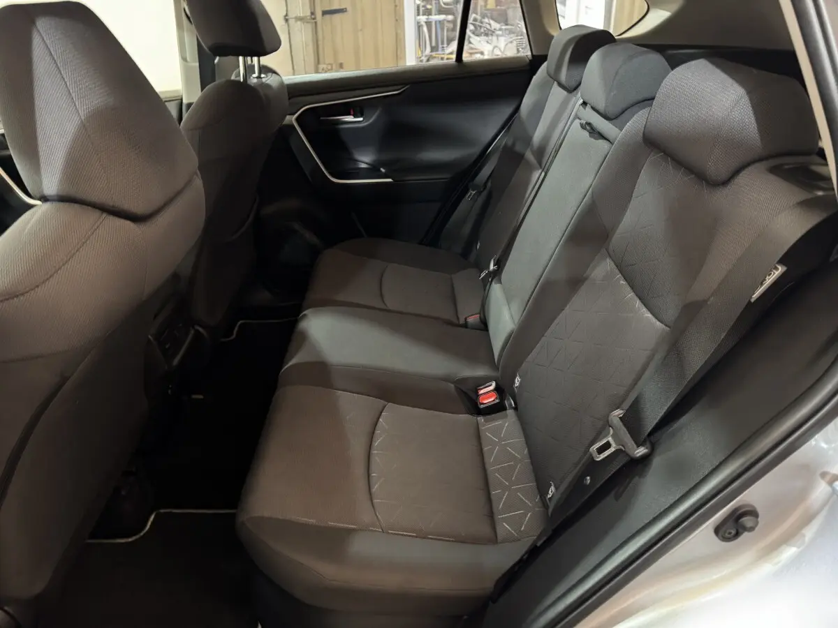 Vue côté droit de la banquette arrière noire du Toyota RAV4 hybride 2021 avec ceinture et appuie-têtes visibles.