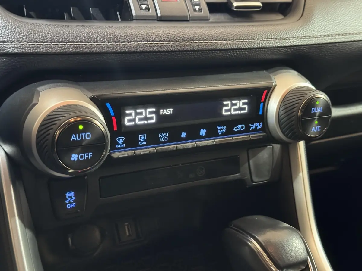 Détail de la climatisation digitale avec réglages dual zone sur tableau de bord noir du Toyota RAV4 gris clair hybride 2021