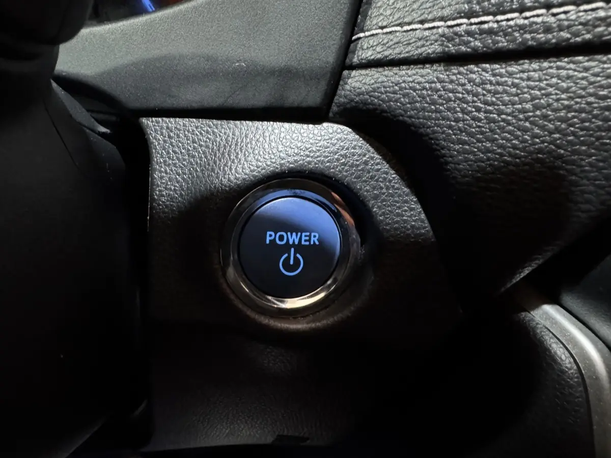 Bouton démarrage Power éclairé en bleu sur tableau de bord noir du Toyota RAV4 Hybride 2021.