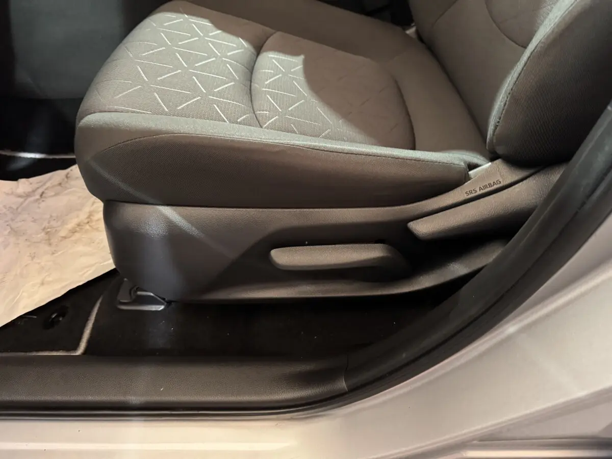 Gros plan sur le siège conducteur gris clair du Toyota RAV4 hybride 2021, avec étiquette SRS Airbag visible sur le côté.