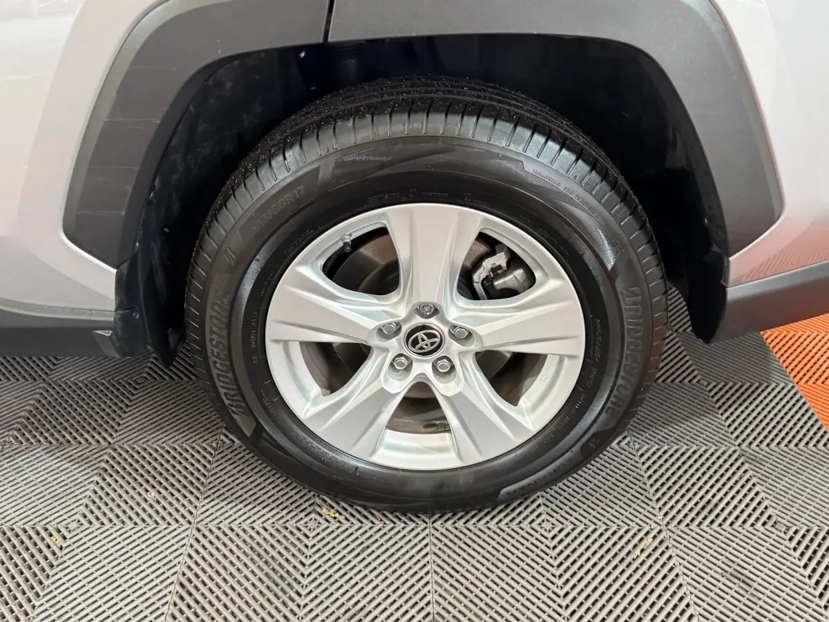 Gros plan sur la roue avant gauche gris clair du Toyota RAV4 Hybride 2021 avec jante alliage cinq branches