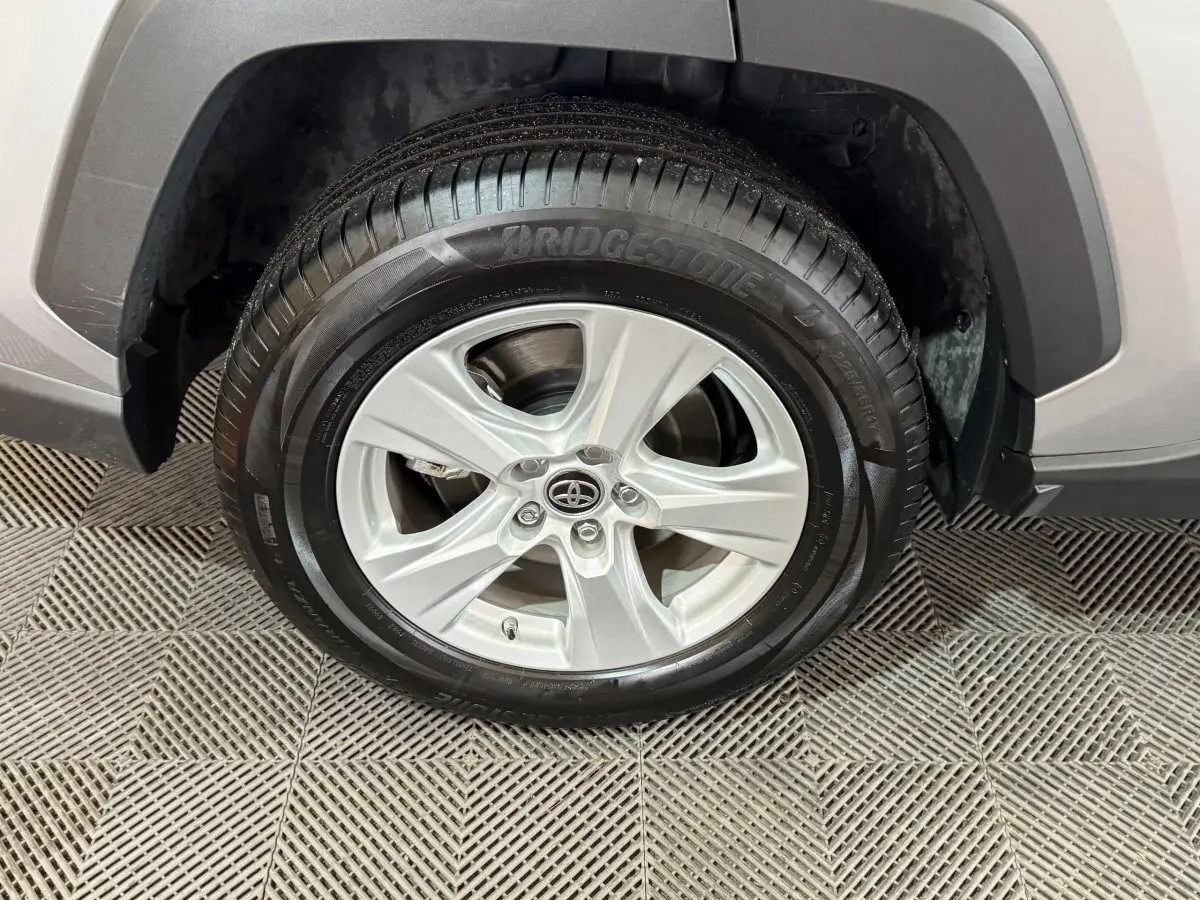 Gros plan sur la roue avant droite gris clair du Toyota RAV4 hybride 2021 avec jante alliage et pneu Bridgestone.