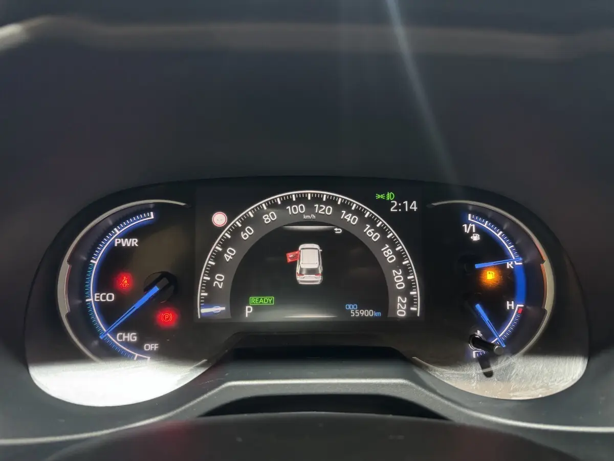 Tableau de bord numérique du Toyota RAV4 hybride 2021 montrant la vitesse, jauges et alertes au centre du véhicule.