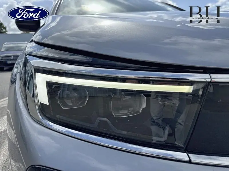 Gros plan sur le phare avant droit du SUV Opel Grandland gris Kontrast Métallisé, mettant en valeur son design LED moderne.