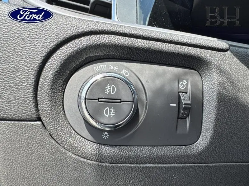 Gros plan sur le bouton de commande des phares et réglage de l’éclairage intérieur d’un Opel Grandland gris Kontrast Métallisé.