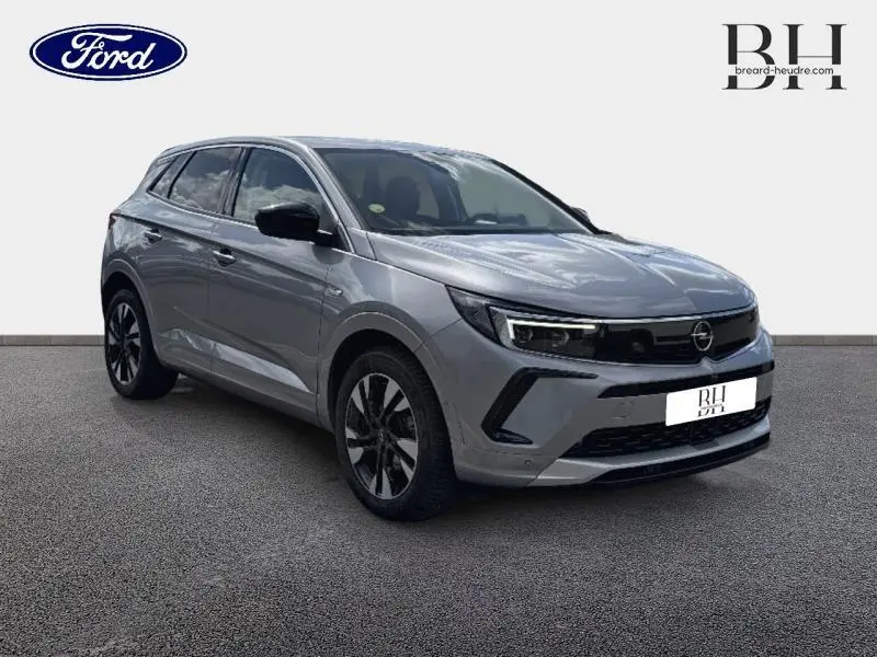 Opel Grandland gris Kontrast métallisé en 3/4 avant droit, avec jantes alliage et calandre noire distinctive.