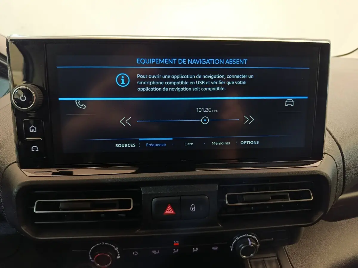Vue intérieure centrée sur l'écran tactile du tableau de bord du Peugeot Partner blanc, affichant un message d'absence de navigation.