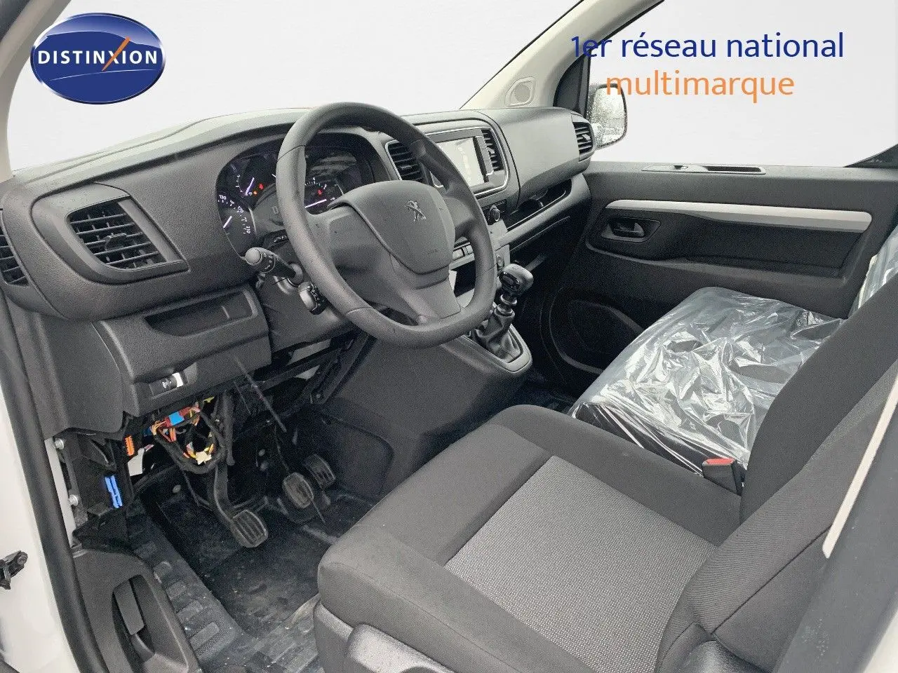 Vue intérieure côté conducteur du Peugeot Expert Long 2023, montrant le volant, tableau de bord et siège avant gris.