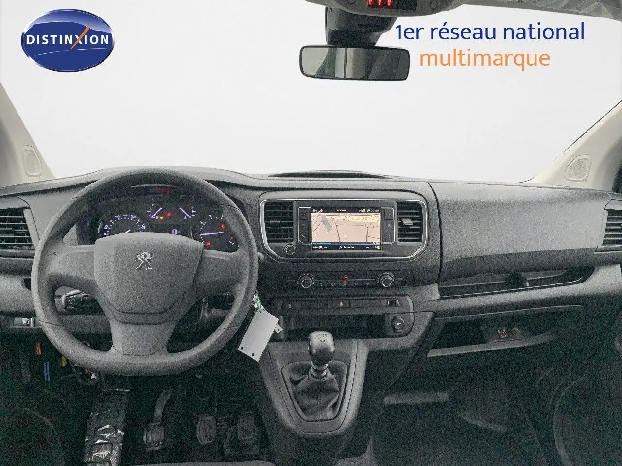 Vue intérieure frontale du tableau de bord noir du Peugeot Expert Long 2023 avec volant, écran tactile et boîte manuelle.