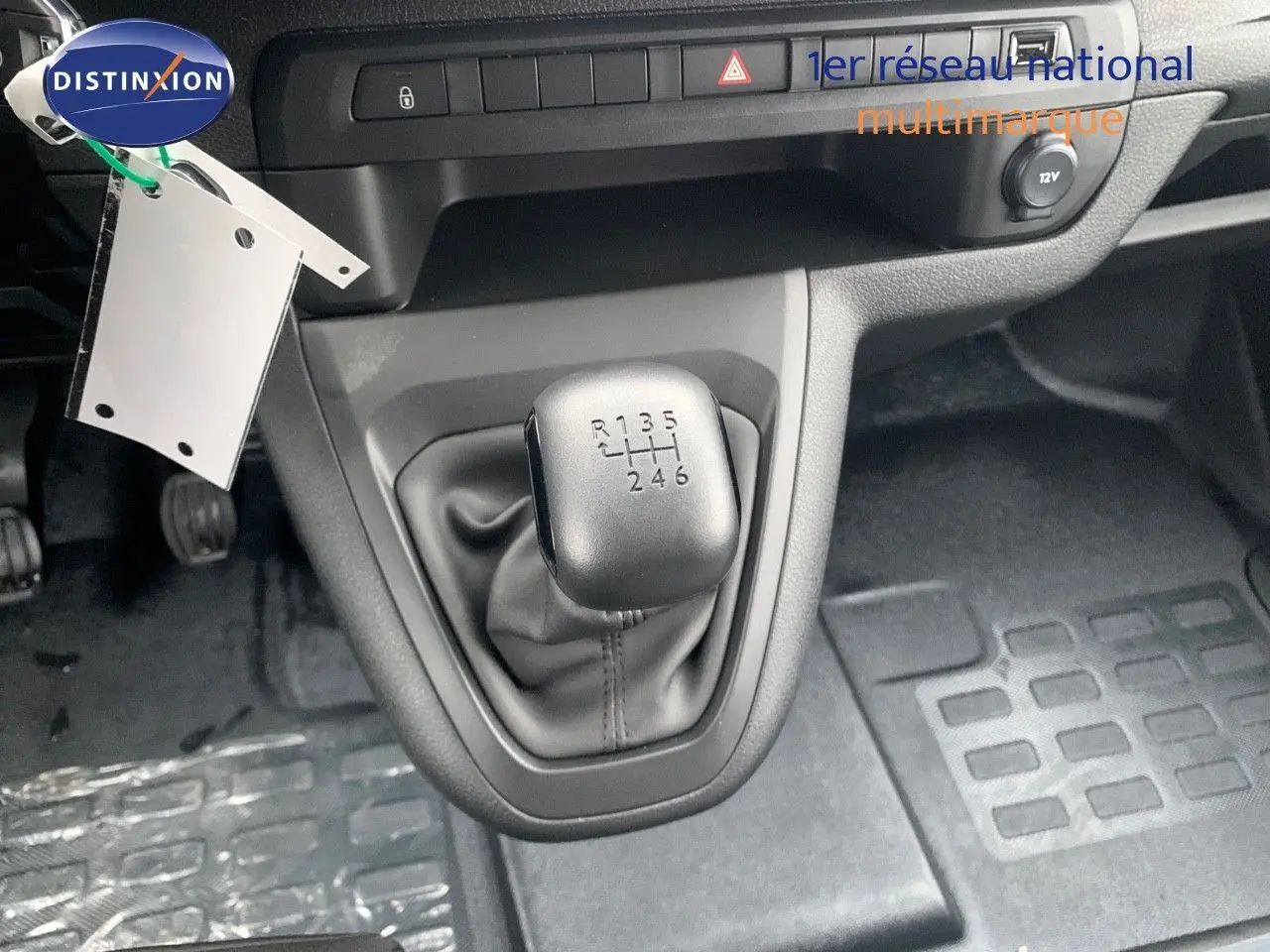 Gros plan sur le levier de vitesses manuel du Peugeot Expert Long 2023, intérieur noir avec tapis caoutchouc.