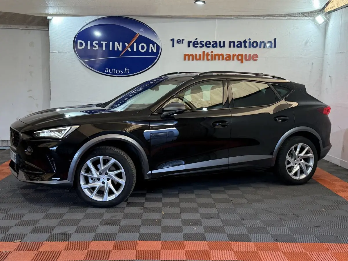 Profil côté gauche d'un SUV CUPRA Formentor noir 2023 avec jantes argentées, dans un showroom intérieur.