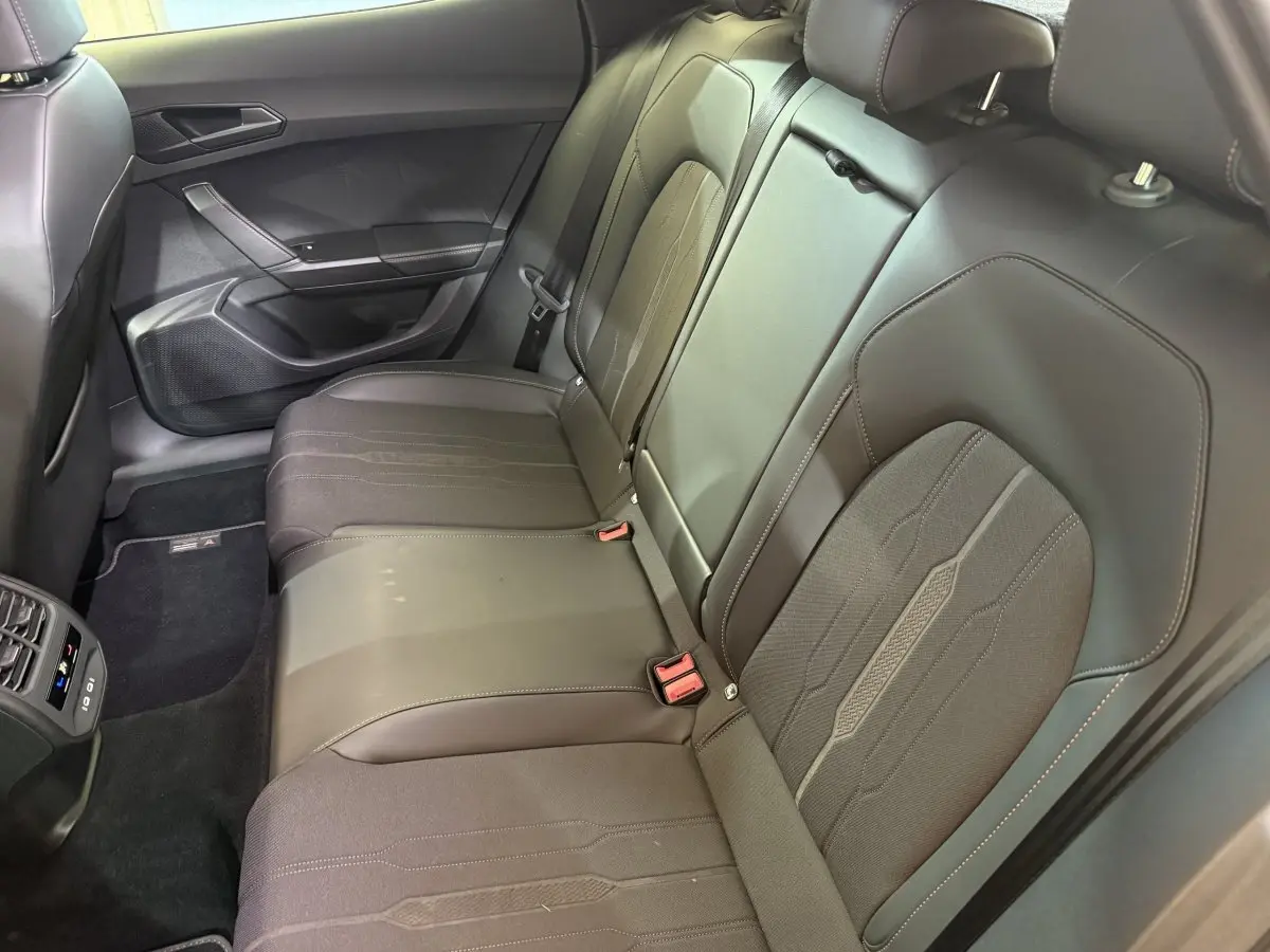 Vue côté droit de la banquette arrière noire en cuir et tissu du CUPRA Formentor 1.5 TSI 2023 avec ceintures visibles.