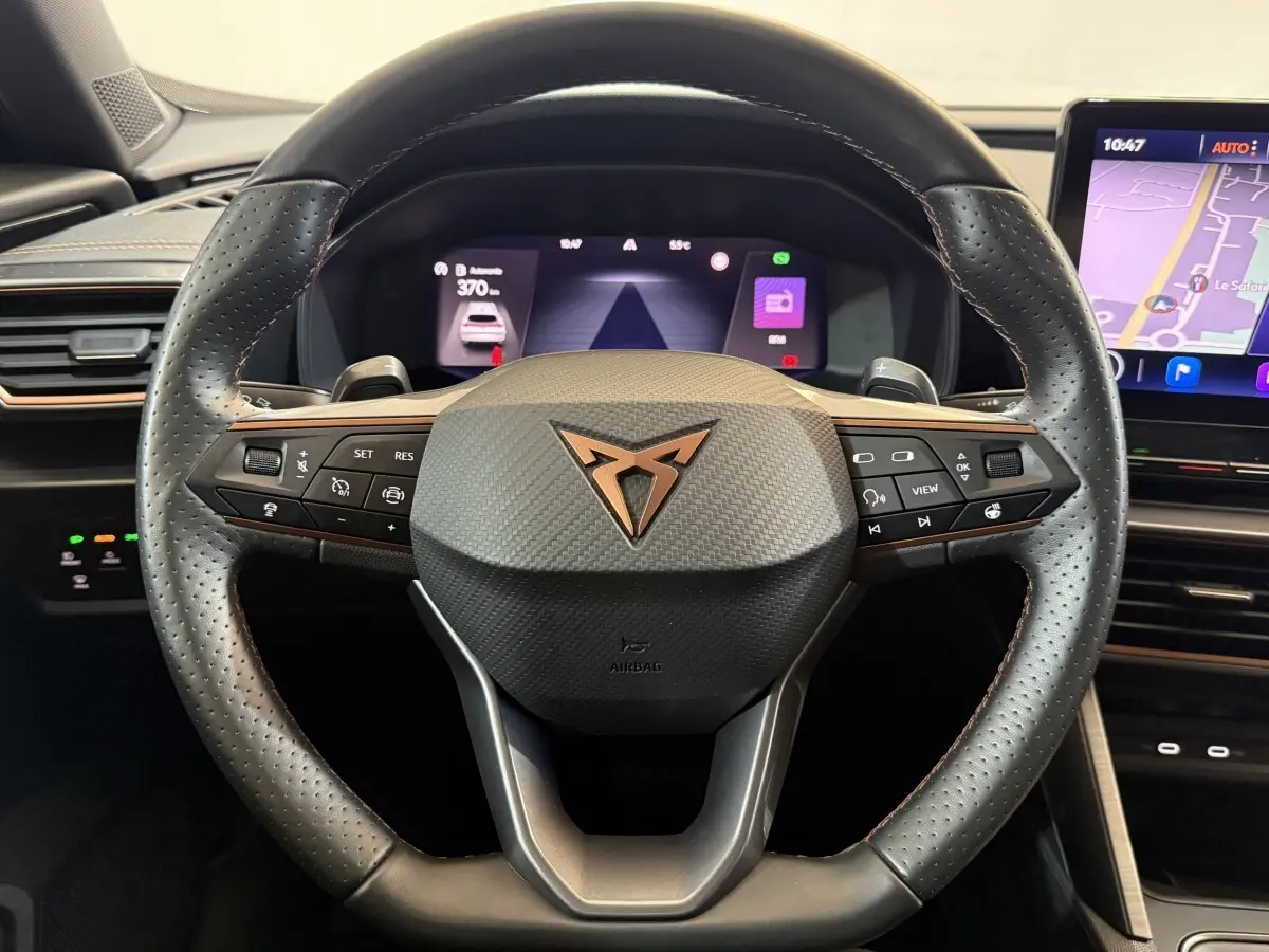 Vue rapprochée du volant cuir noir perforé avec logo CUPRA cuivré et tableau de bord digital du Formentor 2023.