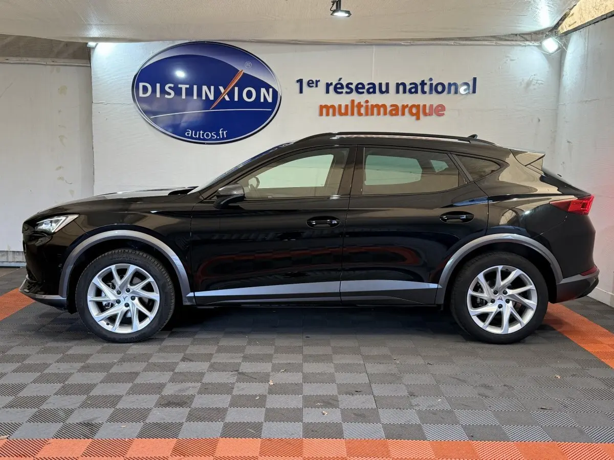 Profil côté gauche d'un SUV CUPRA Formentor noir 2023 avec jantes argentées et barres de toit assorties.