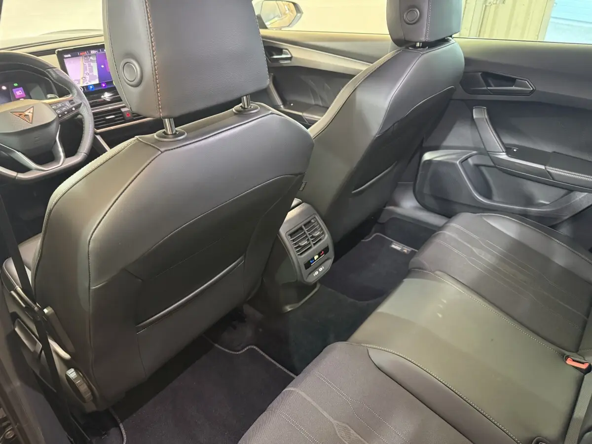 Intérieur arrière noir de la CUPRA Formentor 2023, vue depuis la banquette vers les sièges avant et tableau de bord.