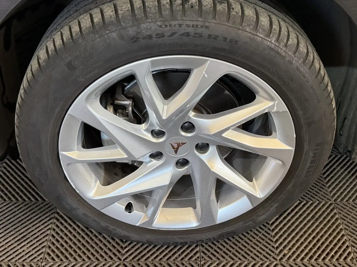 Gros plan sur la jante argentée à 5 doubles branches du CUPRA Formentor noir, mettant en valeur le logo central distinctif.