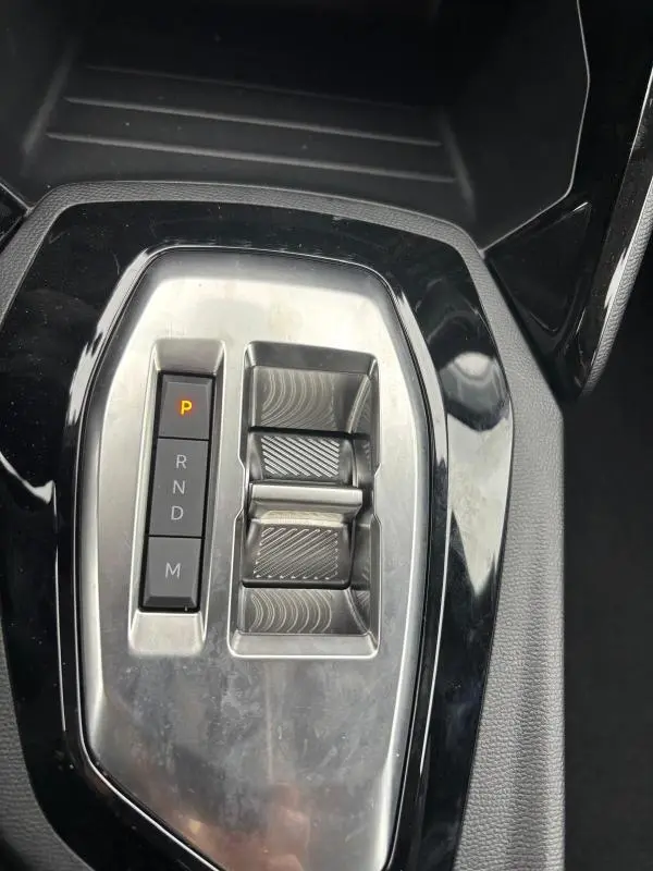 Gros plan sur la commande de boîte automatique de la Peugeot 208 Hybrid 100 e-DCS6 Style, finition noire brillante.