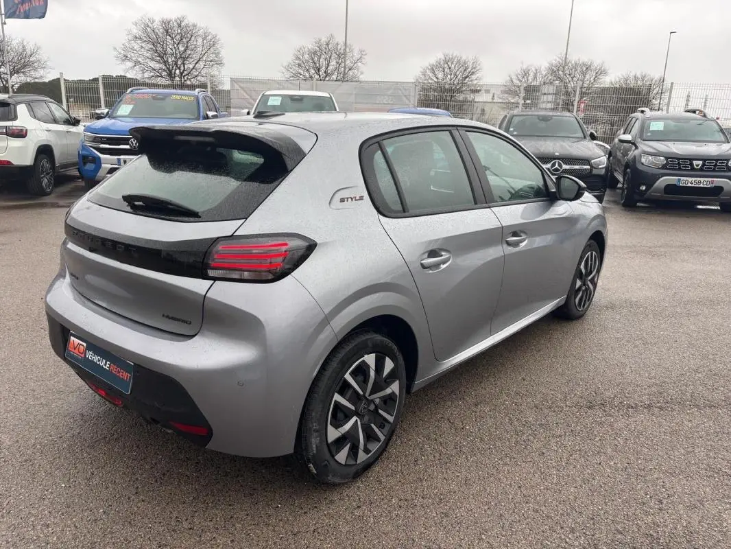 Peugeot 208 Hybrid gris vue 3/4 arrière droit, feux LED, jantes 16 pouces et badge Style sur aile arrière.