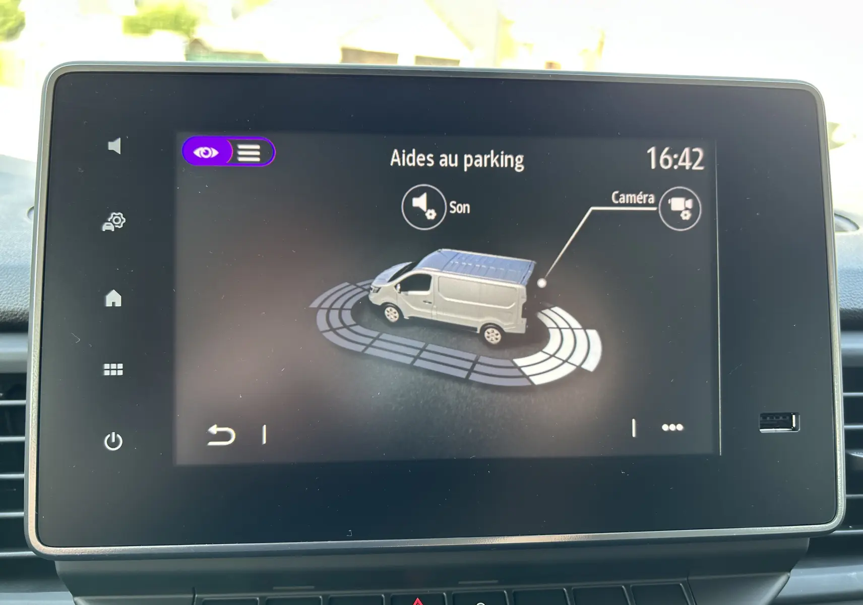 Écran tactile intérieur montrant l'aide au parking avec illustration d'un Renault Trafic blanc en vue 3/4 arrière.