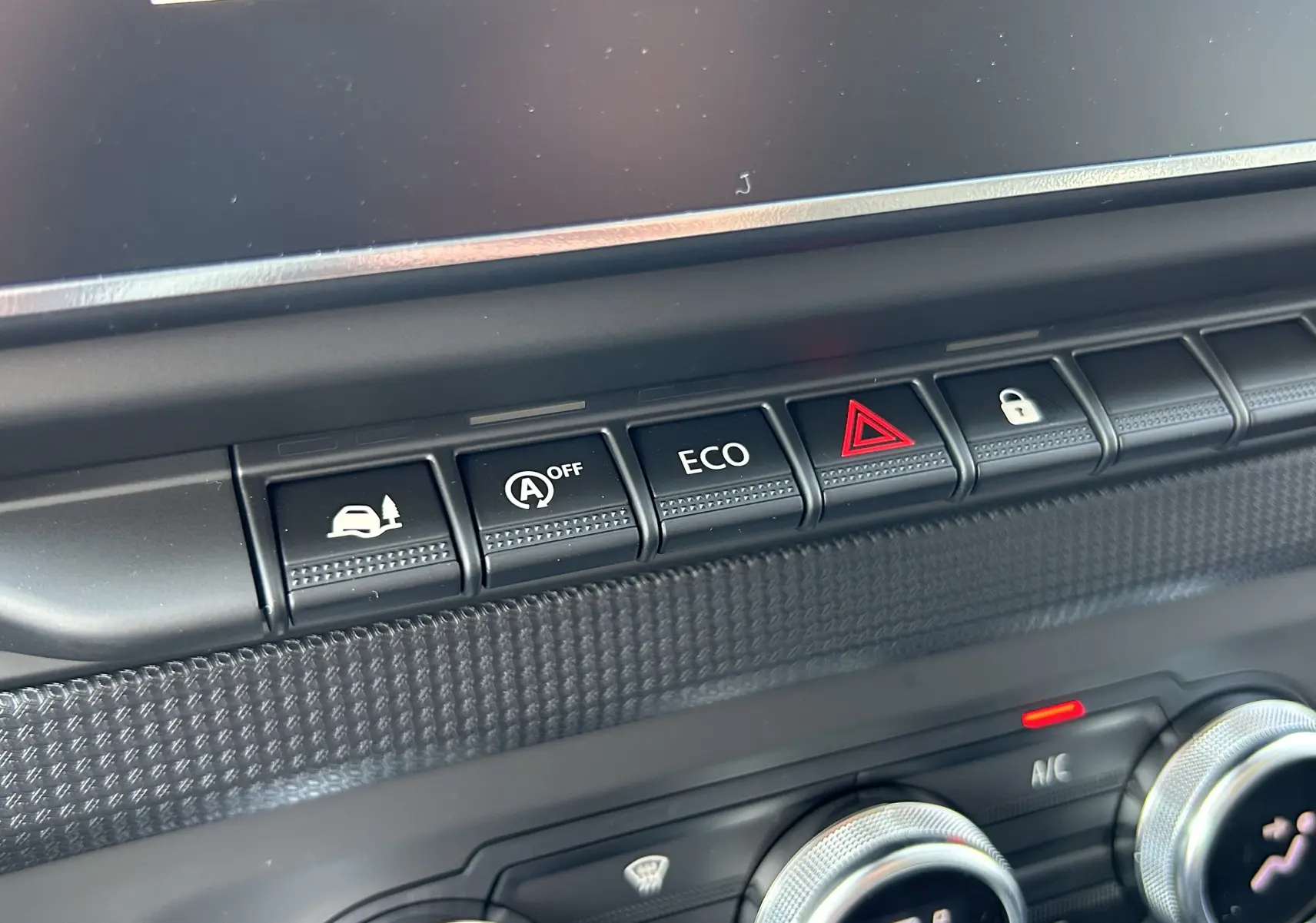 Gros plan sur les boutons de commande du tableau de bord du Renault Trafic blanc, avec fonction ECO et verrouillage centralisé.