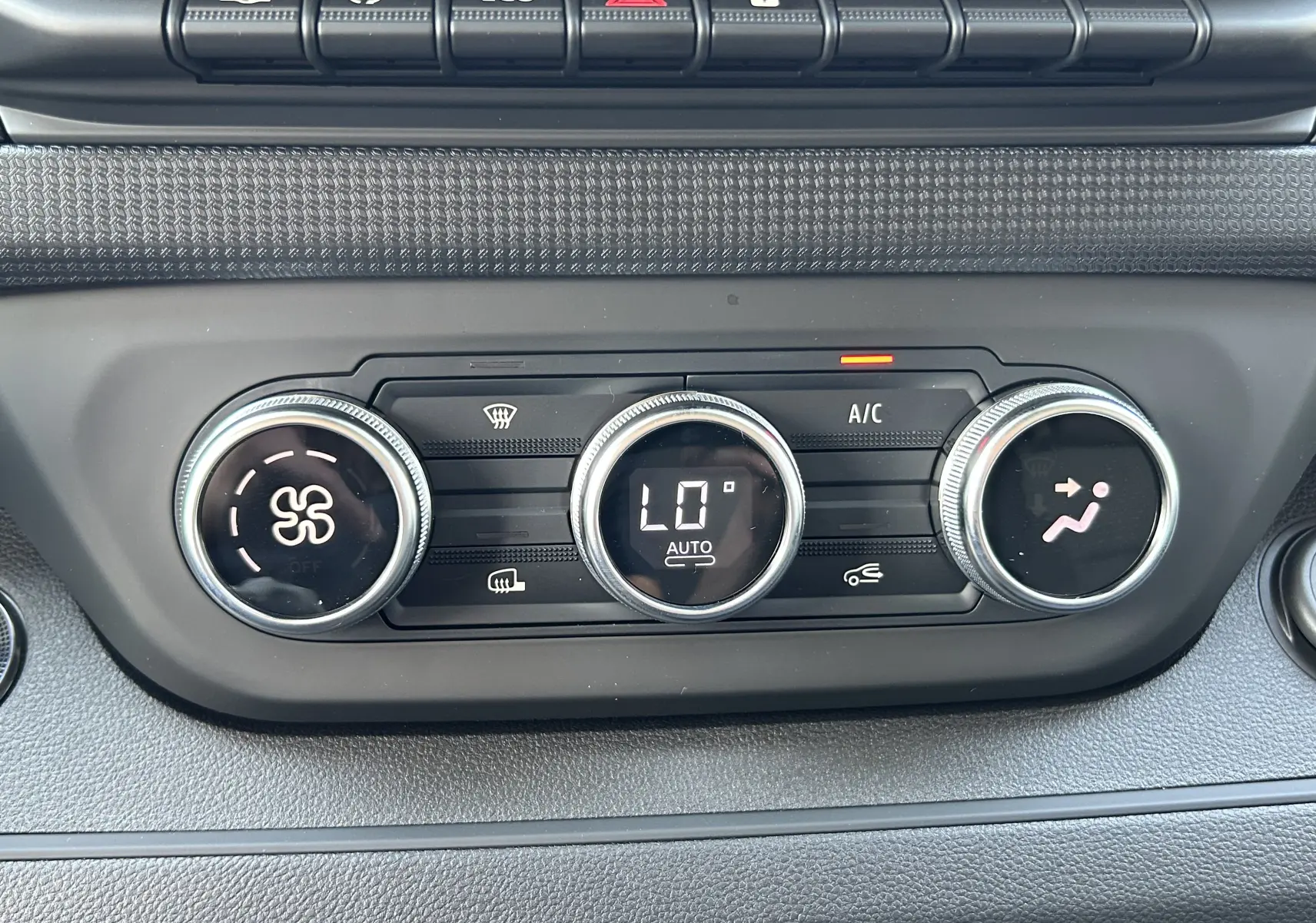 Gros plan sur les commandes de climatisation automatique du tableau de bord du Renault Trafic cabine approfondie blanc.