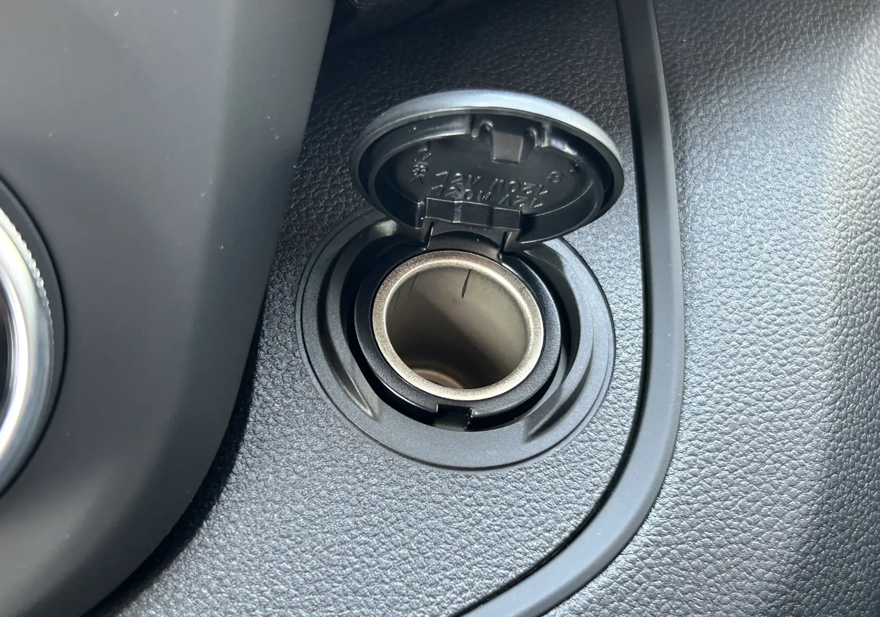 Gros plan sur la prise 12V avec couvercle ouvert dans l'habitacle du Renault Trafic cabine approfondie blanc.