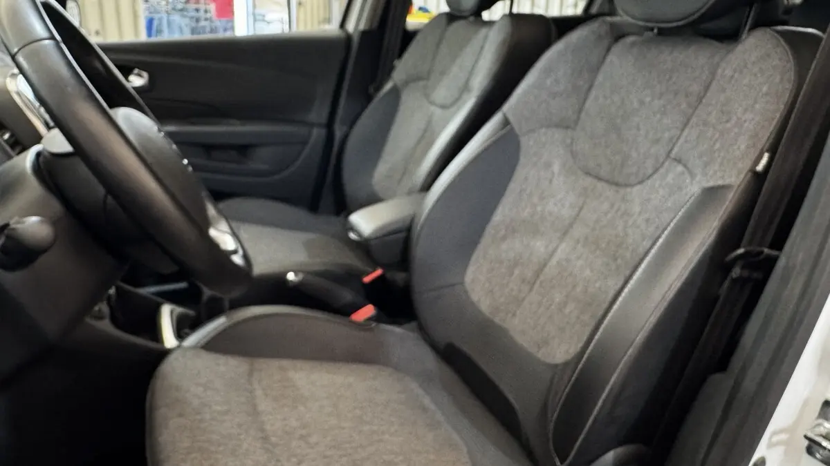 Vue intérieure côté conducteur du Renault Captur Intens TCe 90 2019, sièges tissu gris et volant cuir multifonctions.