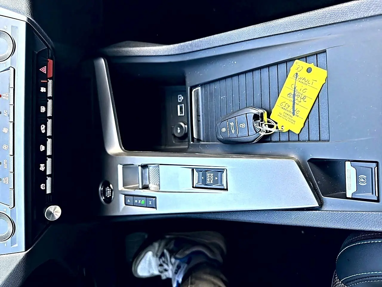 Vue plongeante sur la console centrale de la Peugeot 308 gris selenium avec clé et bouton de démarrage sans clé.