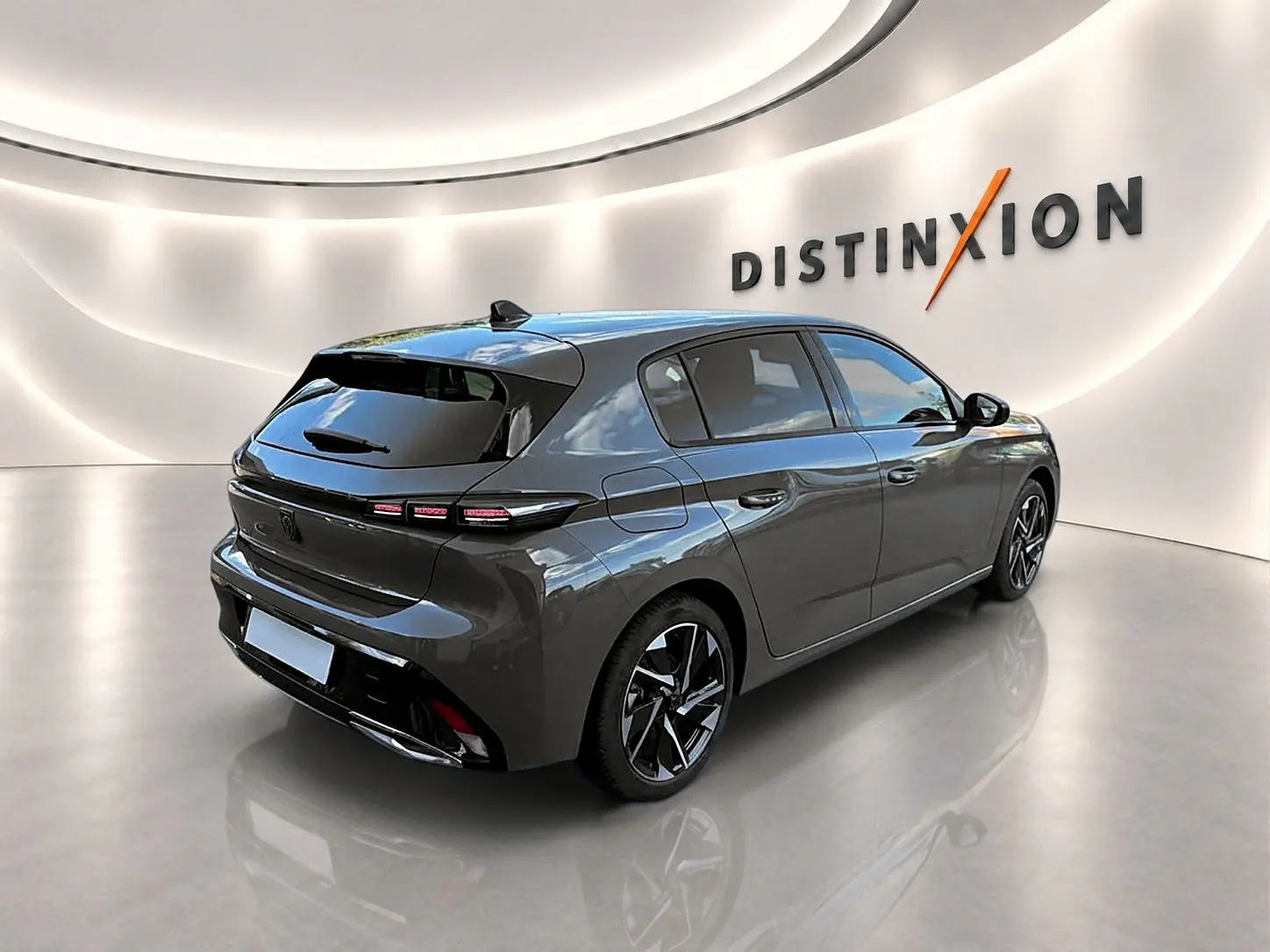 Peugeot 308 gris selenium vue 3/4 arrière droit dans un showroom avec jantes alliage noires et vitres surteintées.