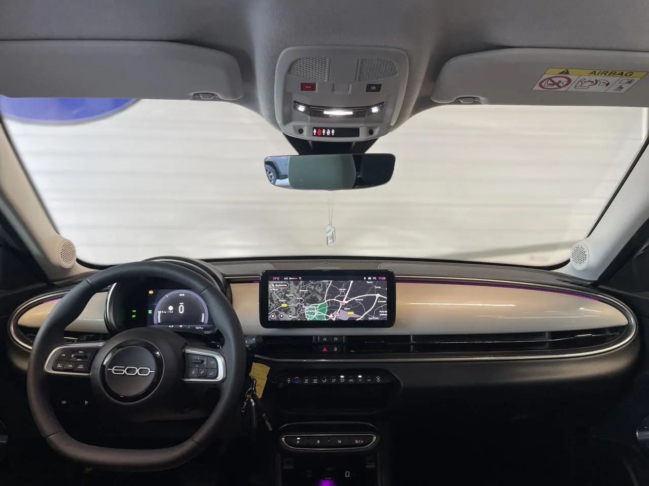 Tableau de bord beige métallisé de la FIAT 600 1.2 Hybrid 2025 avec écran tactile et volant multifonction.