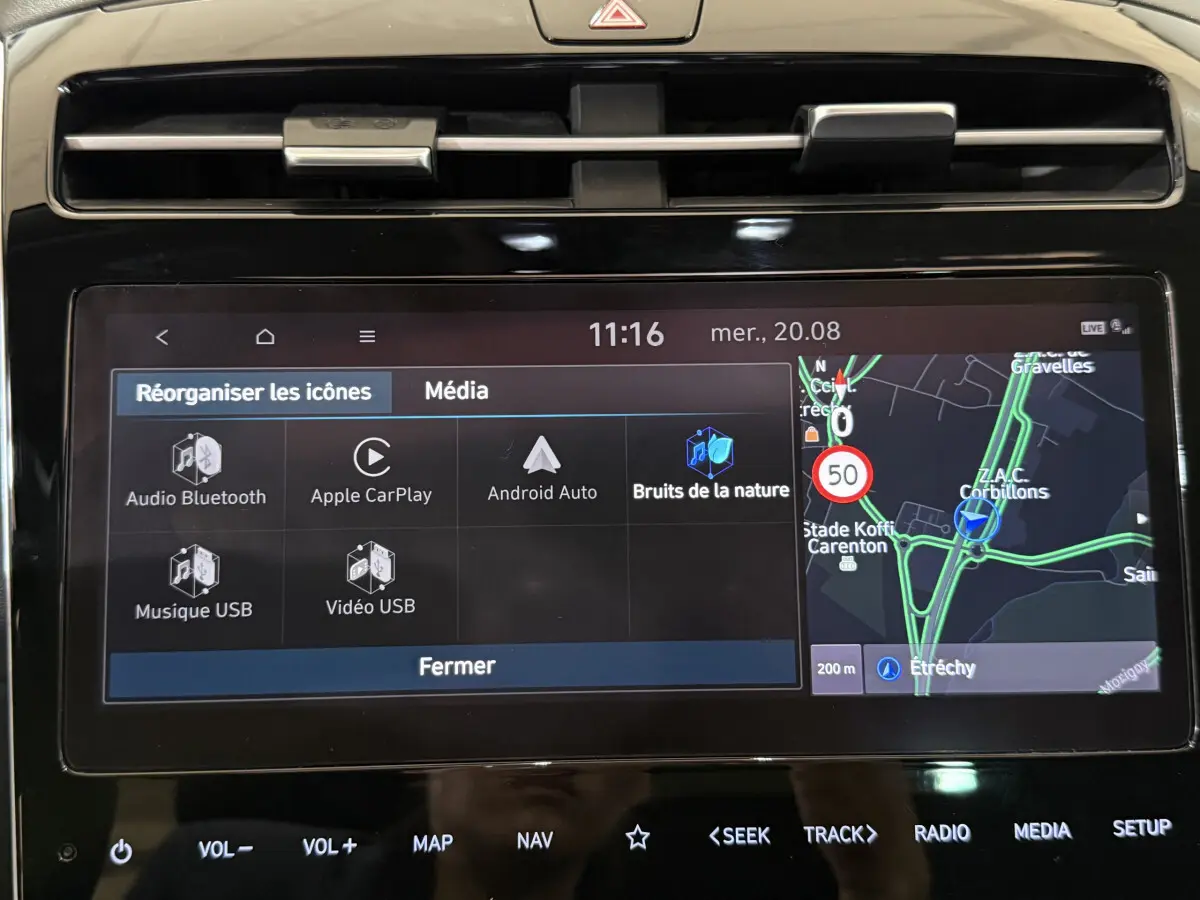 Écran tactile central du Hyundai Tucson noir 2021 affichant navigation et options multimédia en intérieur.