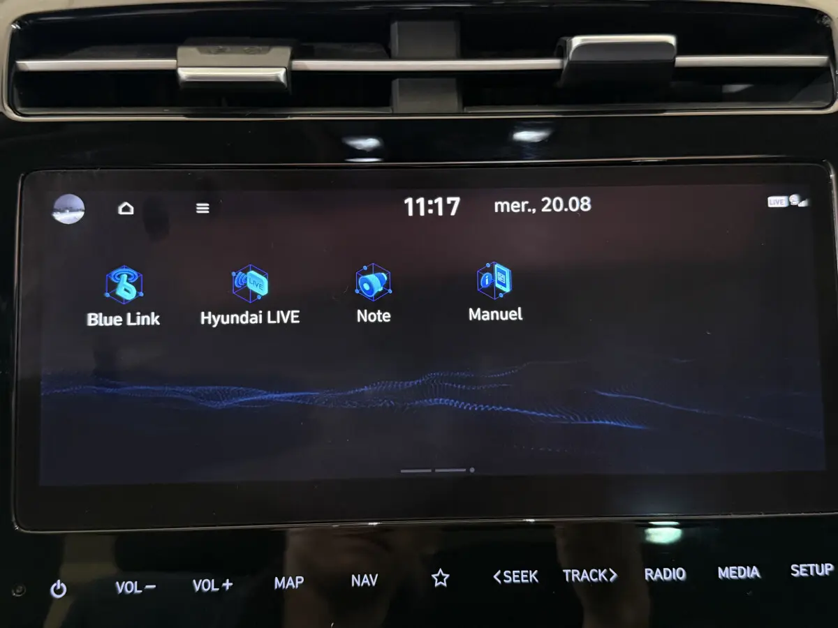 Écran tactile central noir du tableau de bord Hyundai Tucson 2021 affichant applications Blue Link et Manuel.
