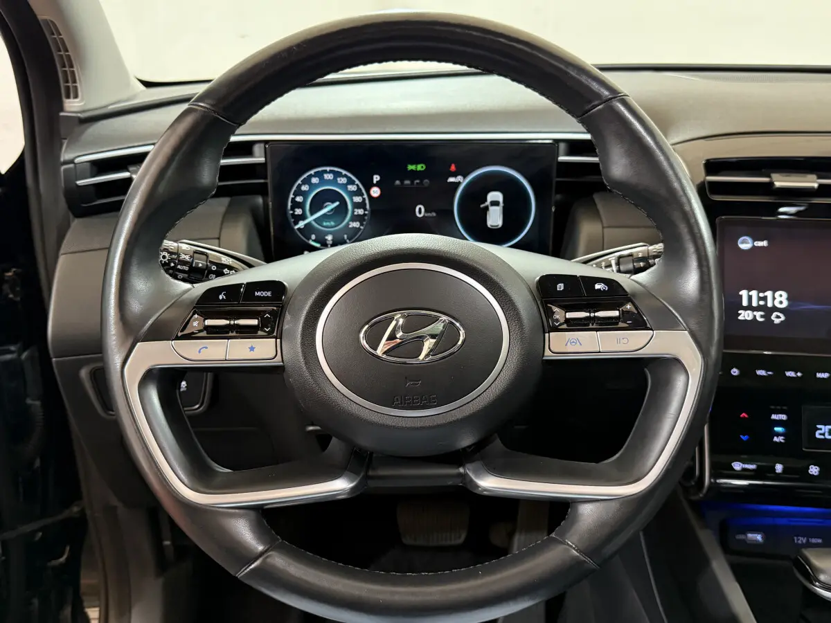 Volant cuir noir et alu du Hyundai Tucson 2021 avec tableau de bord numérique et écran tactile central visible de face