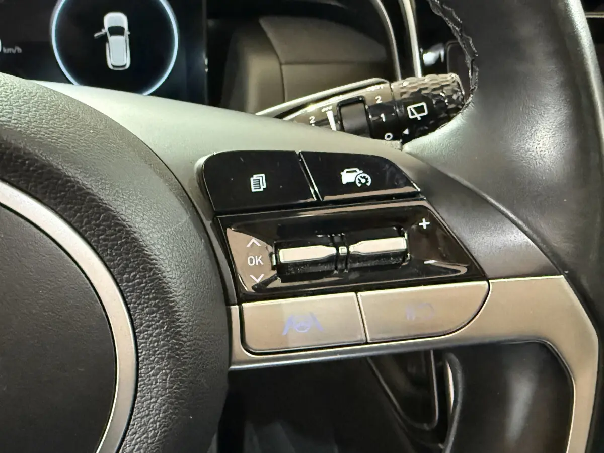 Gros plan sur les commandes multifonctions à droite du volant cuir noir du Hyundai Tucson hybride 2021.