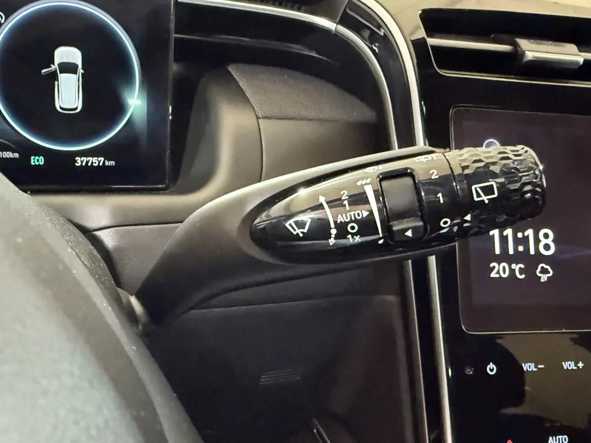 Gros plan sur la commande d’essuie-glace du Hyundai Tucson 2021 hybride, tableau de bord et écran tactile visibles.