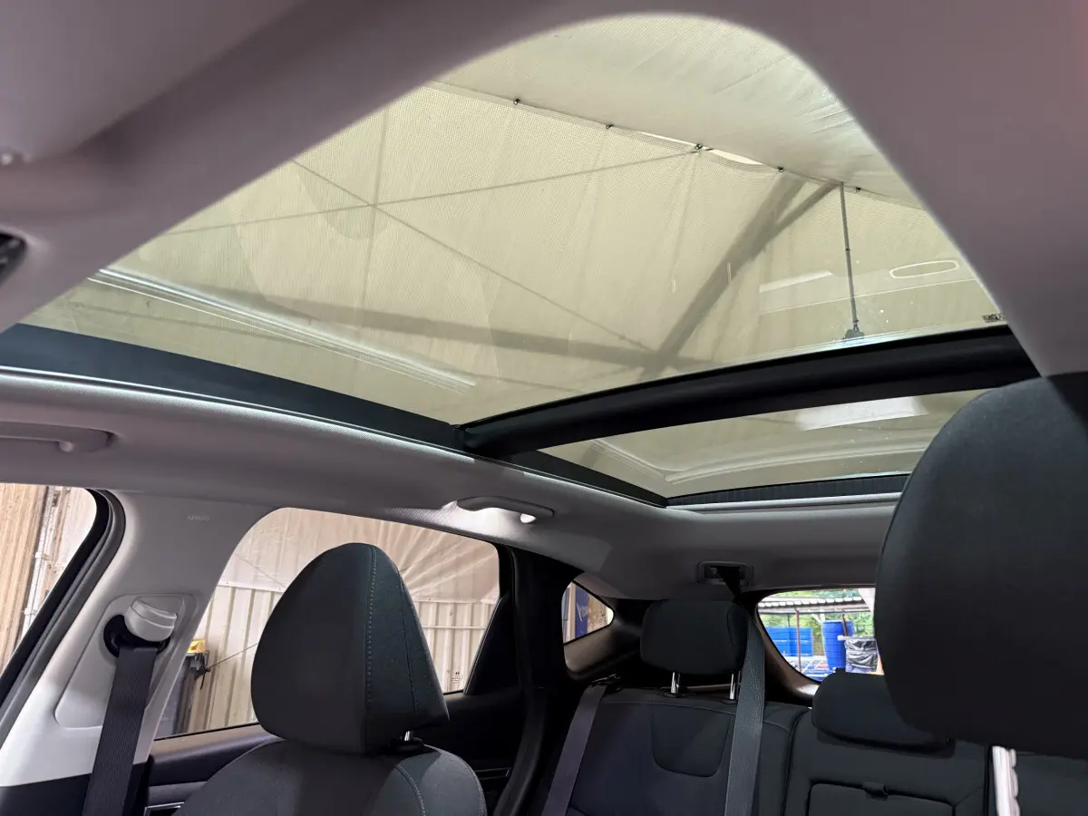 Vue intérieure arrière du Hyundai Tucson noir 2021 avec toit panoramique et sièges noirs visibles.