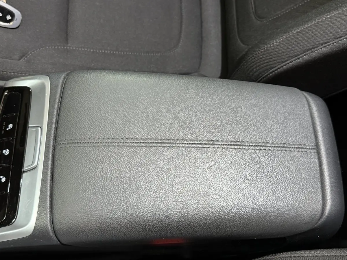 Coffre accoudoir central en cuir noir dans l'habitacle du Hyundai Tucson 2021, avec commandes visibles à gauche.