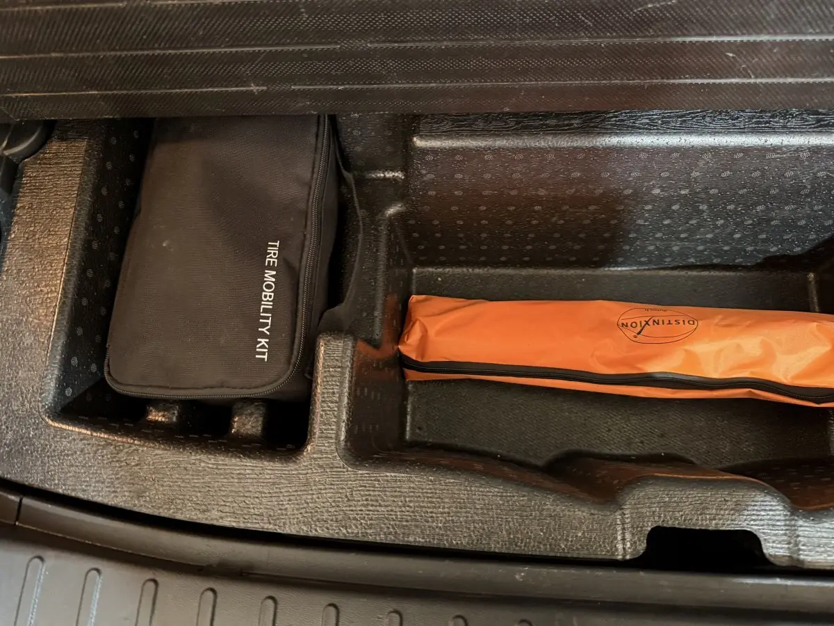 Rangement sous coffre du Hyundai Tucson 2021 avec kit mobilité noir et trousse orange de sécurité.