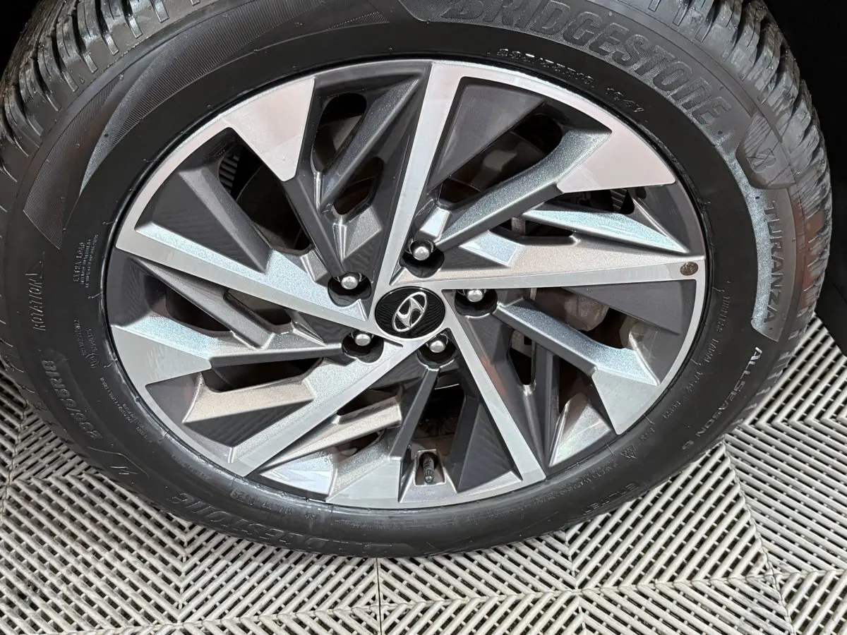 Gros plan sur la jante alliage argentée et noire avec logo Hyundai, montée sur pneu Bridgestone Turanza.